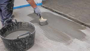 Travailleur appliquant du mortier sur béton